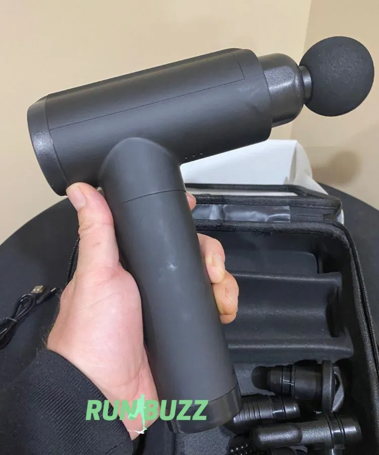 cholas massage gun in hand with the ball attachment in use
